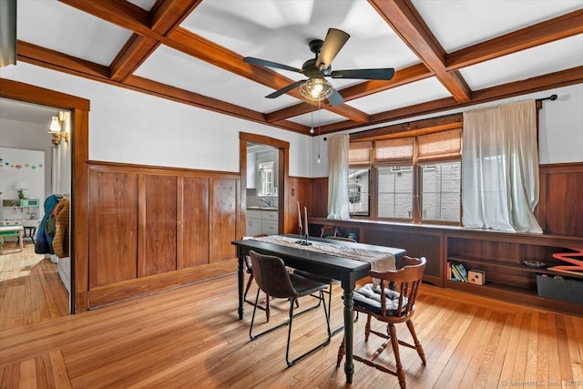 dining area with light wood-style flooring, wainscoting, ceiling fan, coffered ceiling, and beamed ceiling