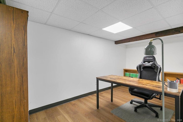 office area featuring a drop ceiling, wood finished floors, and baseboards