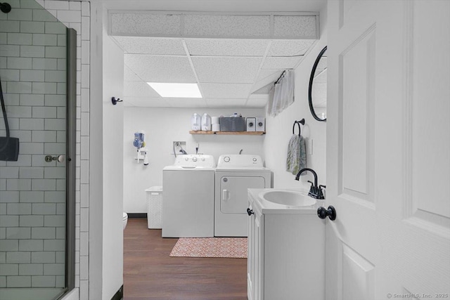 laundry area with washing machine and dryer, laundry area, a sink, and dark wood-style flooring