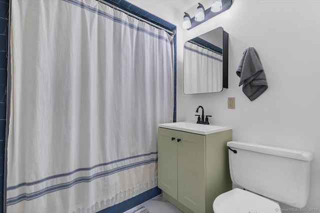 bathroom with curtained shower, vanity, and toilet