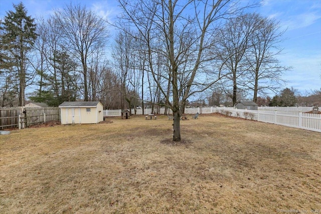 view of yard with an outbuilding, a fenced backyard, and a storage shed