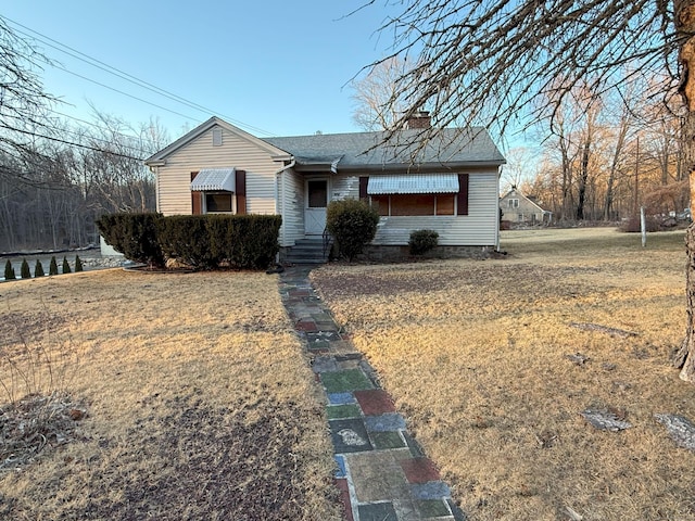 view of front of house featuring a front lawn and a chimney