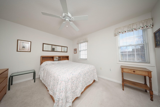 bedroom featuring a ceiling fan, baseboards, and light carpet