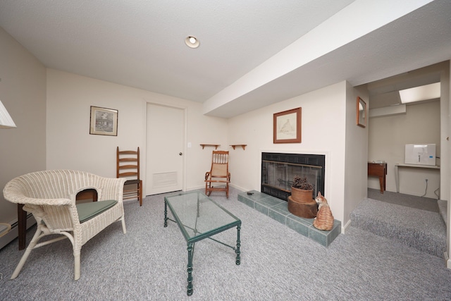 living room featuring baseboards, carpet floors, and a tile fireplace