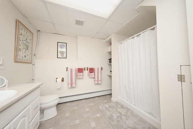 bathroom with visible vents, a drop ceiling, toilet, vanity, and a baseboard radiator