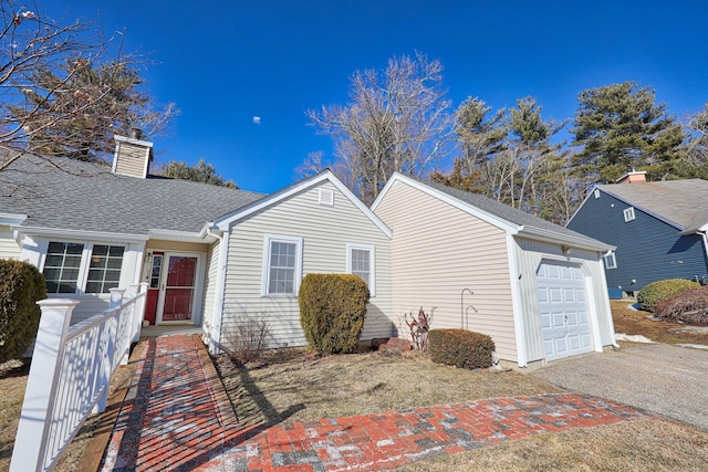 ranch-style home featuring aphalt driveway, an attached garage, a chimney, and roof with shingles