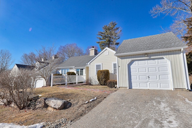 ranch-style home featuring gravel driveway, an attached garage, roof with shingles, and a chimney