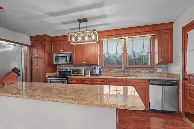 kitchen featuring dark wood finished floors, backsplash, appliances with stainless steel finishes, and a sink