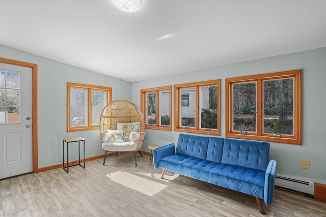 living area featuring wood finished floors, baseboards, and a baseboard radiator