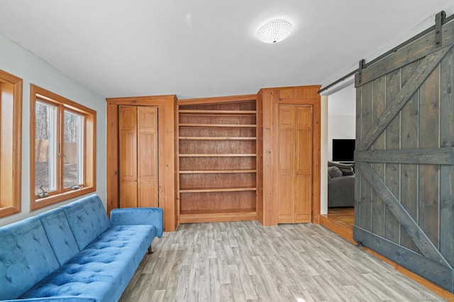 living area featuring a barn door and light wood finished floors