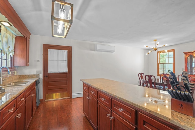 kitchen featuring a sink, dark wood-type flooring, an AC wall unit, baseboard heating, and stainless steel dishwasher