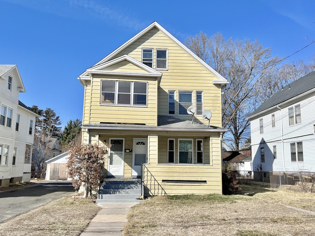 view of front of home featuring covered porch and fence