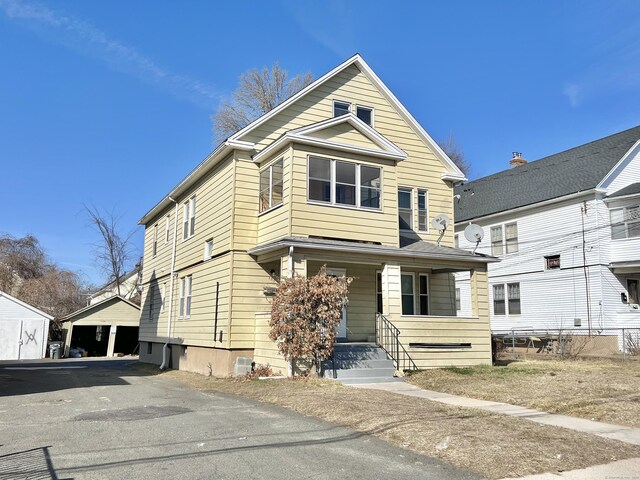 view of front of home with covered porch and a detached garage
