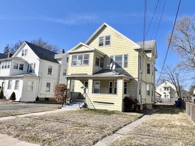 view of front of home featuring a porch and fence