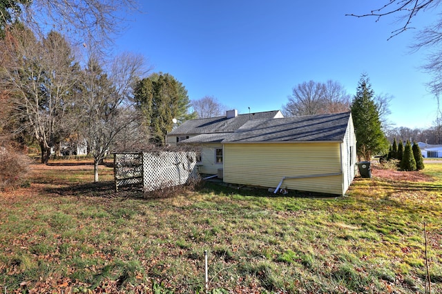 back of house with a lawn and a chimney