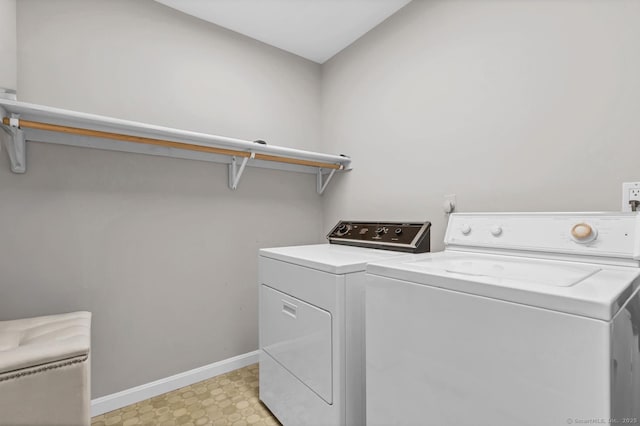 washroom featuring laundry area, baseboards, light floors, and independent washer and dryer