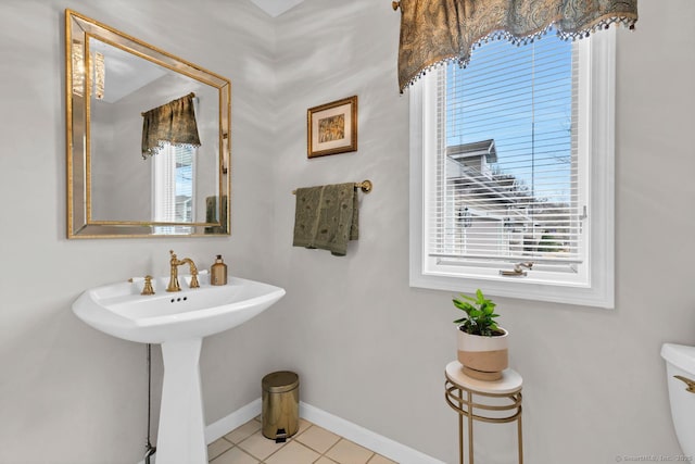 bathroom featuring a sink, tile patterned floors, toilet, and baseboards