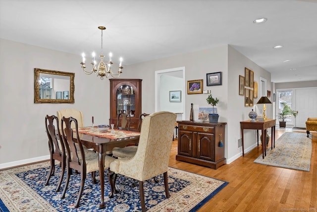 dining space featuring an inviting chandelier, light wood-style flooring, baseboards, and recessed lighting