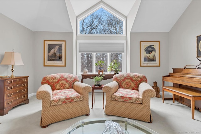 sitting room featuring lofted ceiling, baseboards, and carpet flooring