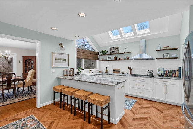 kitchen with white cabinetry, open shelves, decorative backsplash, and exhaust hood