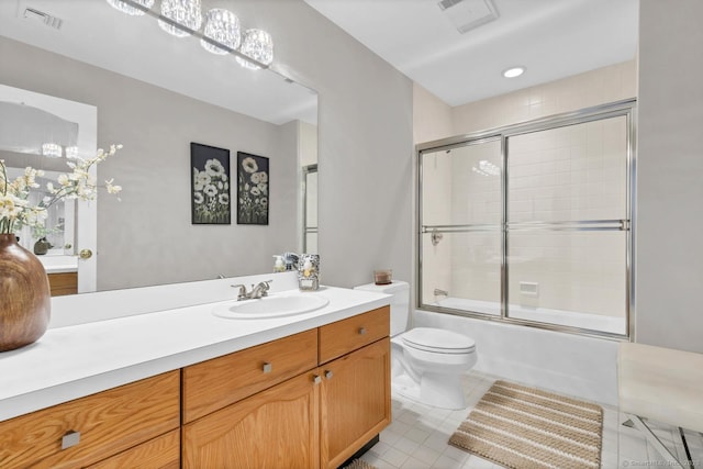 bathroom featuring visible vents, vanity, toilet, and combined bath / shower with glass door