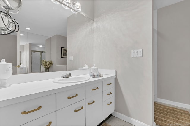 full bathroom with a stall shower, tile patterned floors, baseboards, and vanity