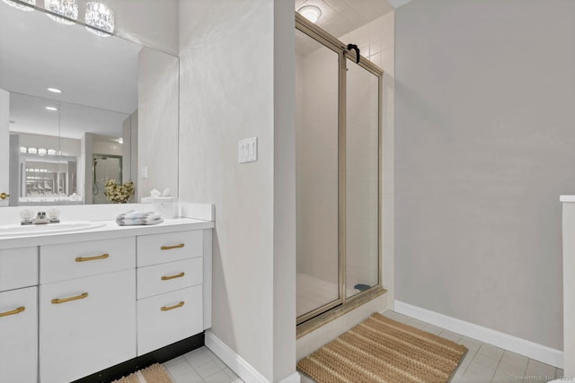 bathroom with tile patterned floors, a shower stall, baseboards, and vanity