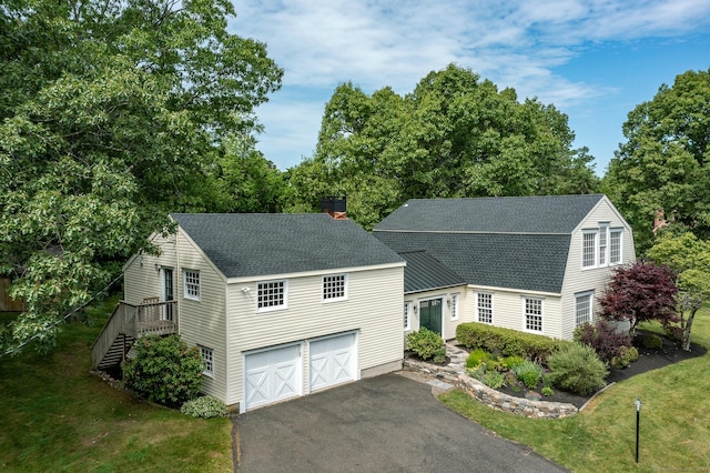 view of front of property with a gambrel roof, a front lawn, roof with shingles, and driveway