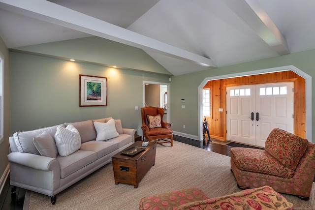 living room with wood finished floors, baseboards, and vaulted ceiling