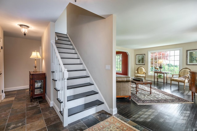 stairs featuring stone finish flooring and baseboards