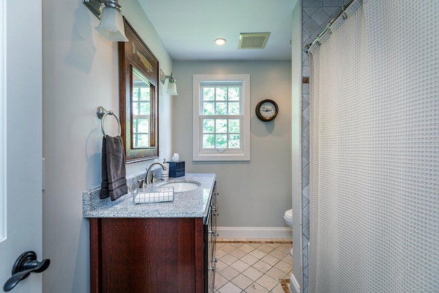 bathroom with vanity, baseboards, visible vents, tile patterned floors, and toilet