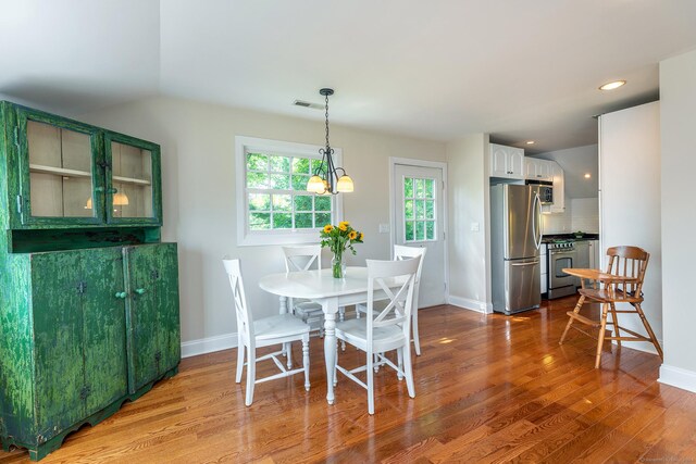 dining space featuring visible vents, baseboards, a chandelier, recessed lighting, and wood finished floors