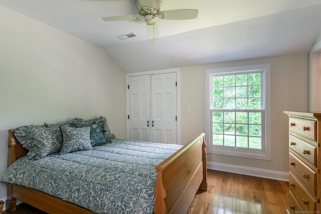 bedroom featuring visible vents, a ceiling fan, hardwood / wood-style flooring, baseboards, and lofted ceiling