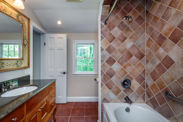 bathroom featuring tile patterned flooring, a healthy amount of sunlight, vanity, and vaulted ceiling