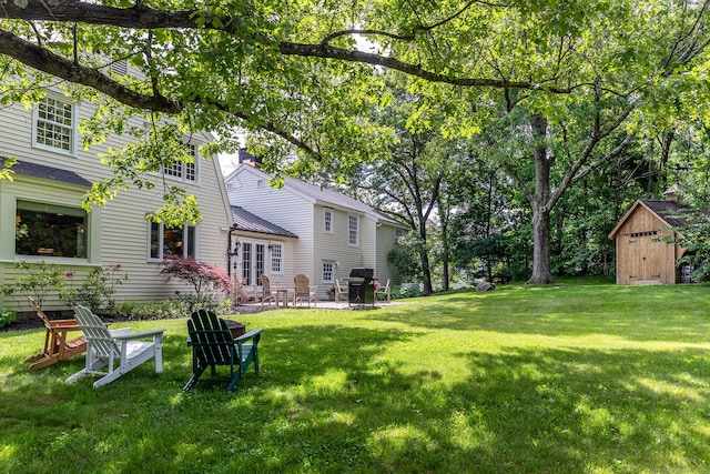 view of yard with a patio, an outdoor structure, and a shed