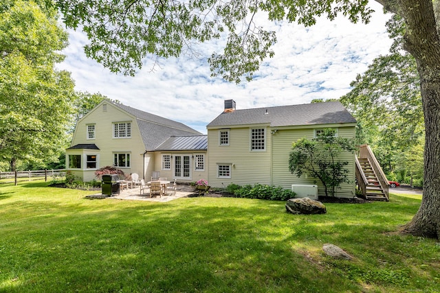 rear view of property featuring fence, roof with shingles, a yard, a gambrel roof, and a patio area