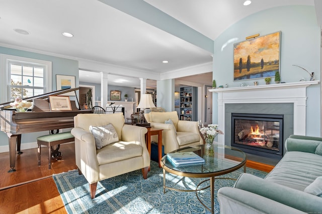 living room with a fireplace with flush hearth, ornamental molding, wood finished floors, recessed lighting, and ornate columns