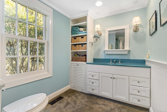 bathroom with visible vents, toilet, crown molding, baseboards, and vanity