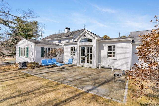 rear view of property featuring an outdoor living space, french doors, a patio, and a yard