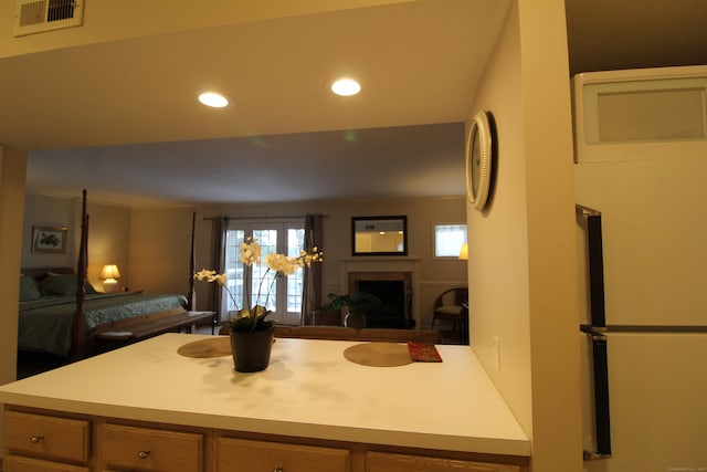 kitchen featuring a fireplace, recessed lighting, light countertops, visible vents, and open floor plan