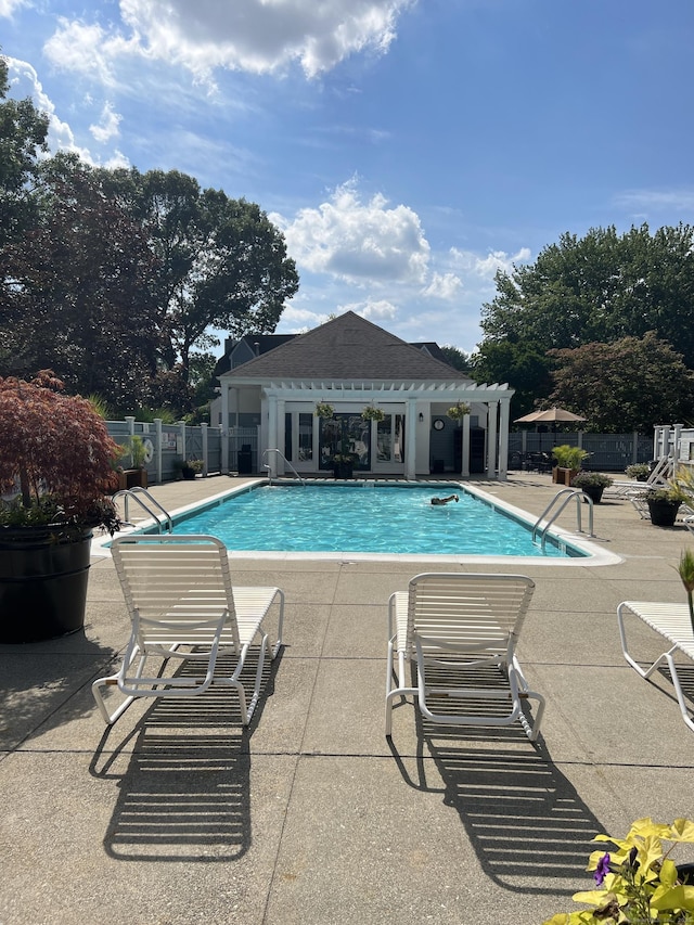 community pool with a patio, a storage structure, an outdoor structure, and fence