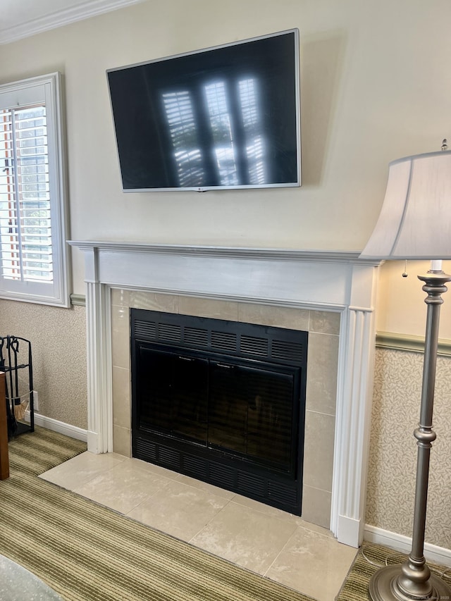 interior details with wallpapered walls, crown molding, and a tile fireplace