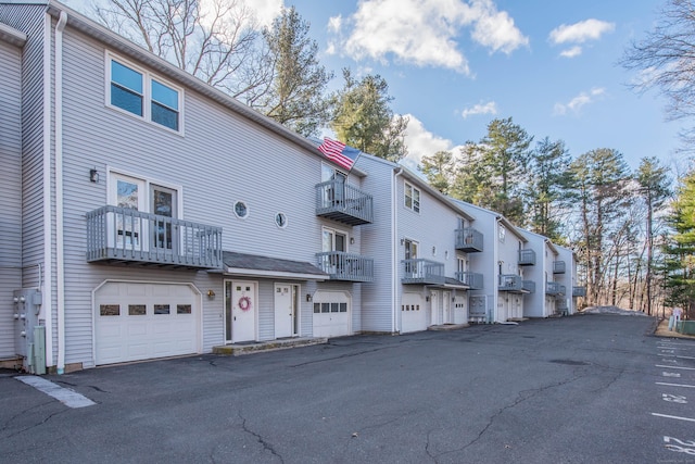 view of property featuring driveway, an attached garage, and a residential view