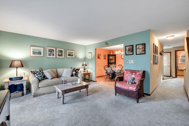 living room with light carpet, baseboards, and an inviting chandelier