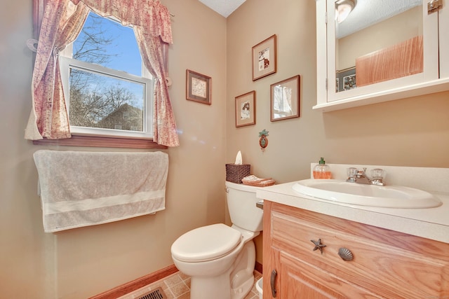 bathroom with toilet, baseboards, and vanity