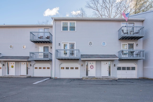 multi unit property featuring a garage and driveway