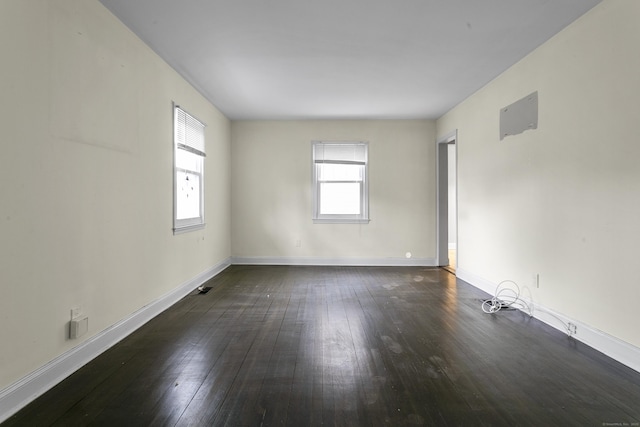 empty room featuring dark wood finished floors and baseboards