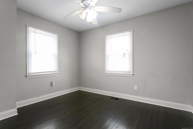 empty room featuring a ceiling fan, a wealth of natural light, and dark wood finished floors