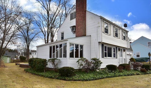 view of side of property featuring a garage, a yard, and a chimney