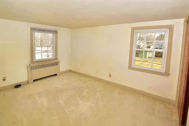 unfurnished room featuring light carpet, radiator heating unit, and baseboards